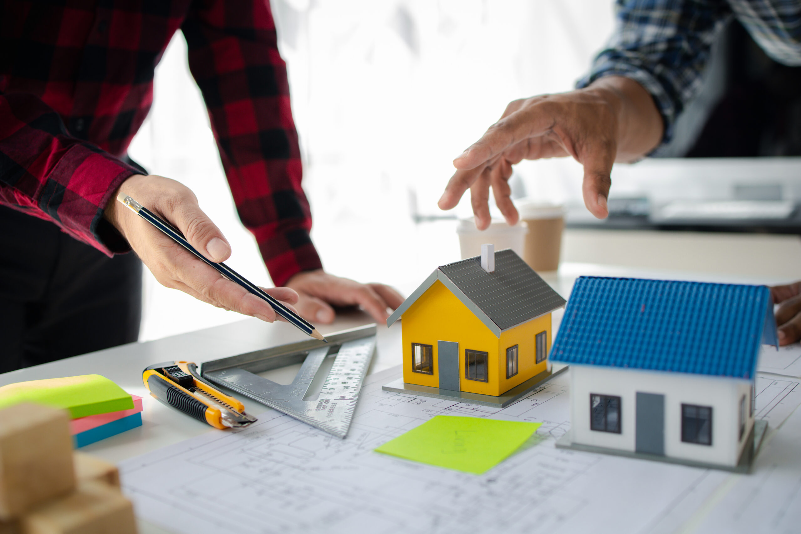 The home design architects are reviewing the house plan draft, t The home design architects are reviewing the house plan draft, the project commissioned by the client, and the custom design before delivery. Interior design and decoration ideas.